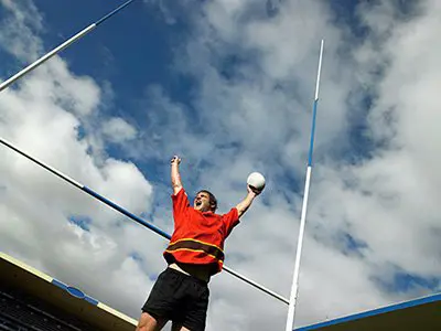 male student holding rugby ball