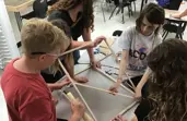 Students building an outdoor bean bag toss