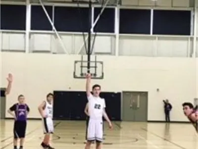 Male basketball player shooting on net