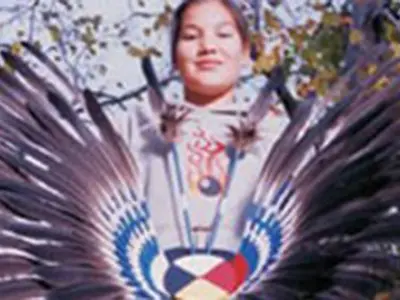 Boy holding feathered headdress