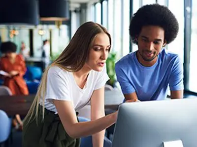 A girl and boy looking at a computer screen