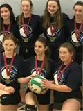 Female volleyball players holding volleyball