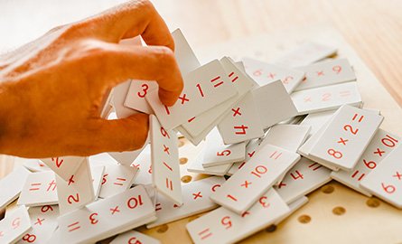 A hand picking up times table cue cards