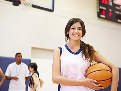 female student holding basketball