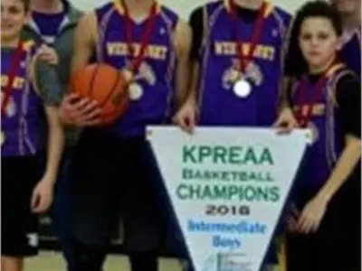 Male basketball players holding championship banner