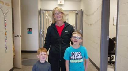 Custodian with two students in the hallway