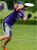 Student reaching to catch frisbee