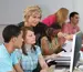 Teacher helping students in a computer lab