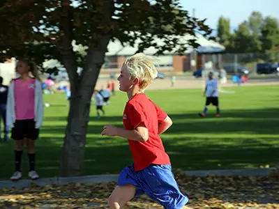 male student running on a trail