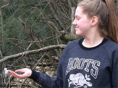 Student feeding a bird