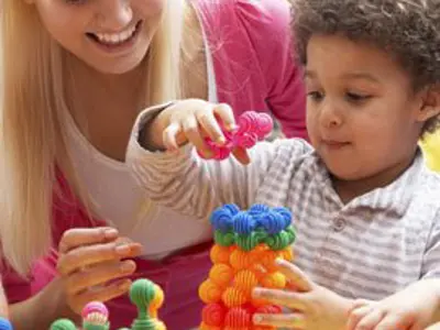 Teacher and student working with blocks; image of child playing with stacking blocks