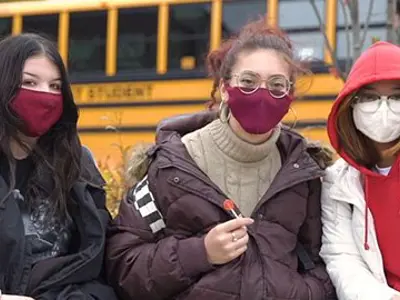 Three students outside, wearing masks 